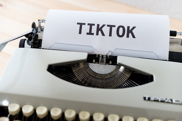 Een afbeelding van een typemachine met een stuk papier erin, bedrukt met het woord 'TikTok'.
