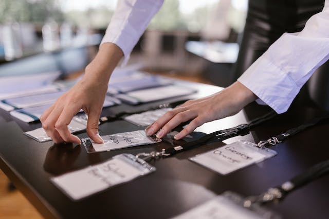 A person arranges ID tags on a table. 