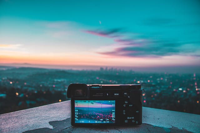 Een digitale camera wordt op een dak geplaatst om 's nachts foto's van de stad te maken. 