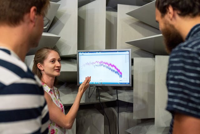 A woman presents graph data to her team. 