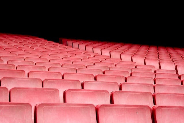 A conference hall with red, empty seats.