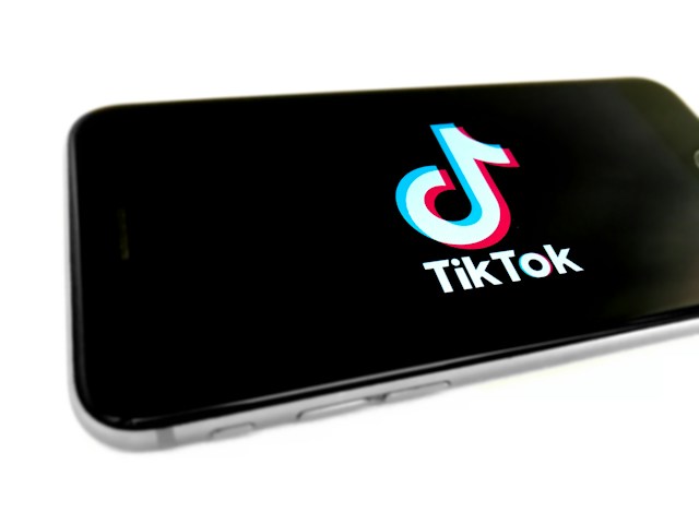 Een gekantelde smartphone met het TikTok-logo op het scherm.