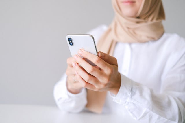 Eine Frau versucht, mit ihrem Handy ein TikTok-Video hochzuladen.