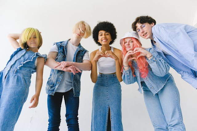Een groep jongeren poseert voor de camera terwijl ze harttekens maken met hun handen. 