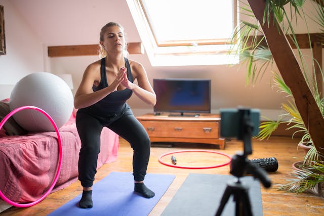 Une femme enregistre son programme de remise en forme pour les personnes qui la suivent.