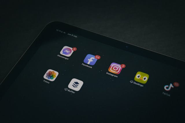 Een tabletscherm toont verschillende pictogrammen van sociale media-apps met rode meldingen.