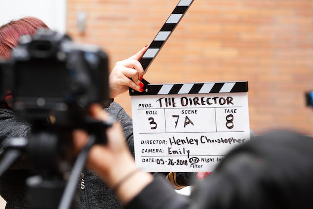 A person holds a clapper board.
