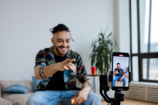 Un bărbat se așează în fața telefonului său pentru a înregistra un nou videoclip TikTok.