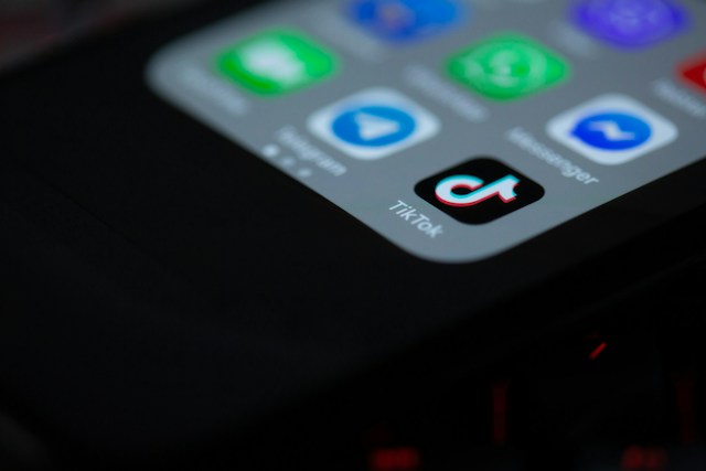 Un téléphone noir affiche l'icône de l'application TikTok.