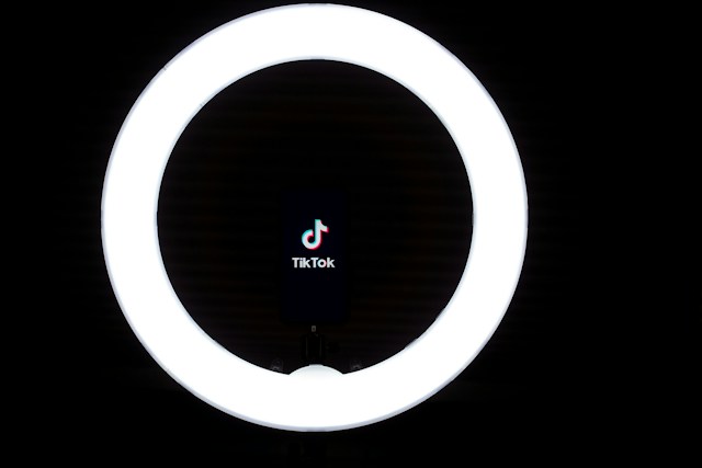 Un telefono all'interno di un anello luminoso rotondo mostra il logo di TikTok.