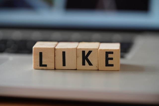 Four cubes with alphabets form the word "LIKE."