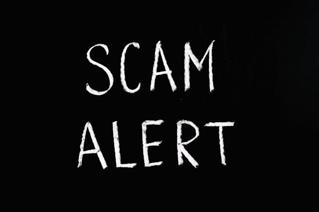 黒板に書かれた白い「SCAM ALERT」のメッセージ。