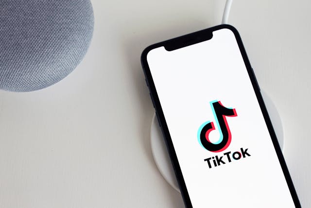 A phone screen displays the TikTok logo and name. 