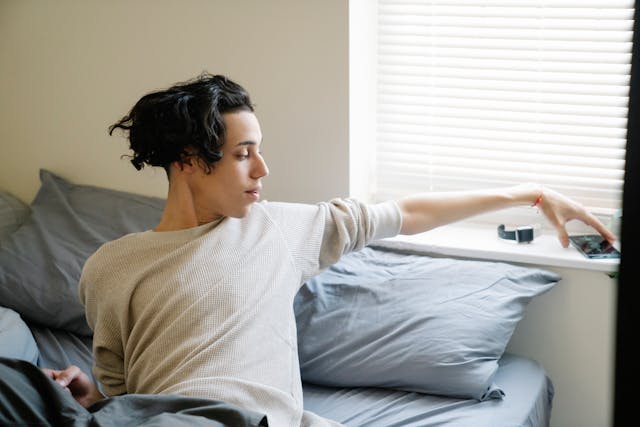 A person picks up their phone from the windowsill to check for updates.