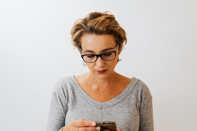 Een vrouw controleert haar telefoon op TikTok-meldingen. 