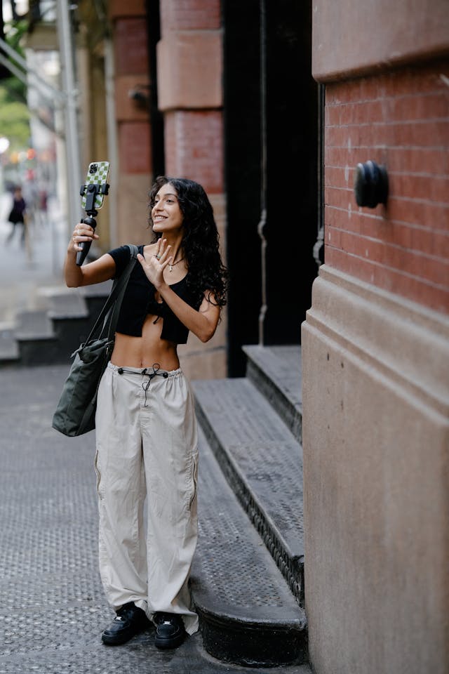 A woman records with her selfie stick.
