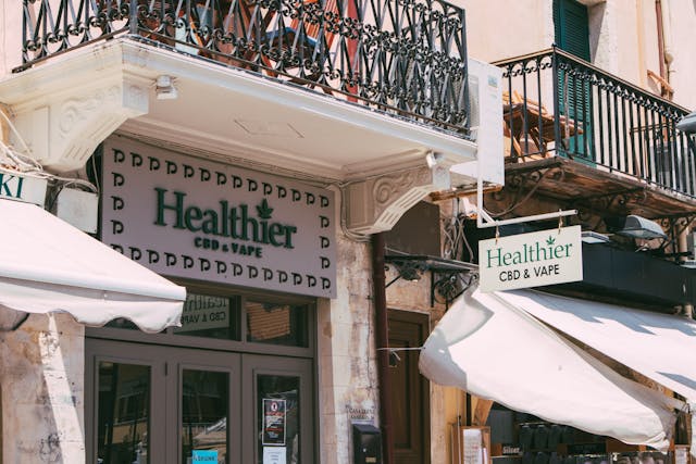 Business signage in front of a store that says, “Healthier CBD and Vape.”