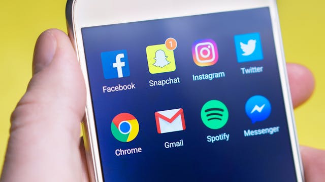 Auf einem Telefonbildschirm werden verschiedene Social-Media-Apps angezeigt.