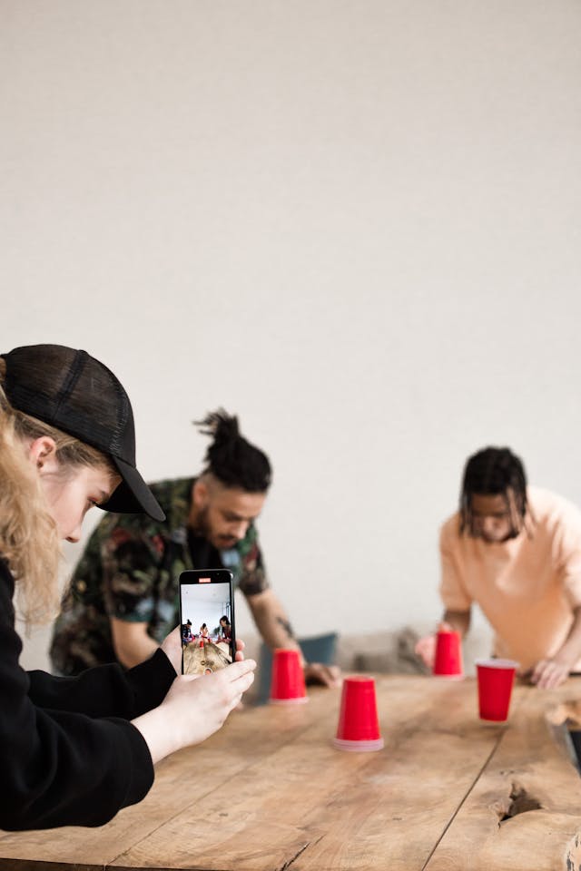 Someone records men playing a game with red cups.