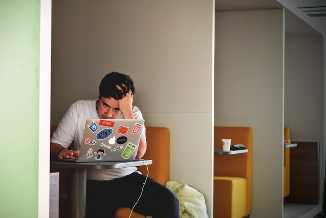 Een man kijkt verward terwijl hij een bericht van TikTok op zijn laptop leest.