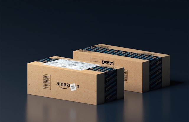 Two boxes with the Amazon logo stand side by side.
