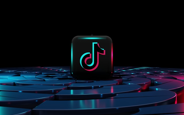 A black cube features the TikTok logo and sits on top of a maze-patterned table. 
