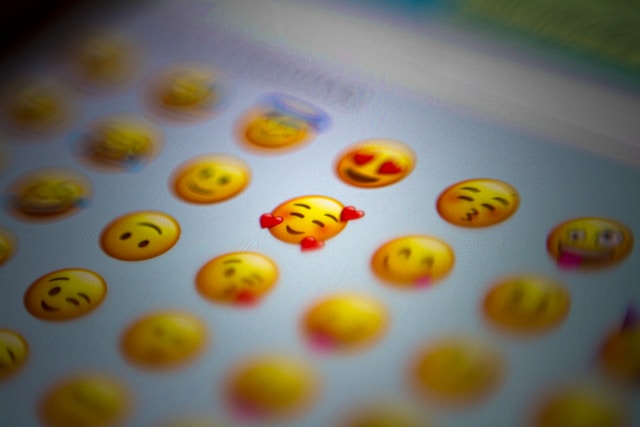 A digital screen displays popular emojis. 

