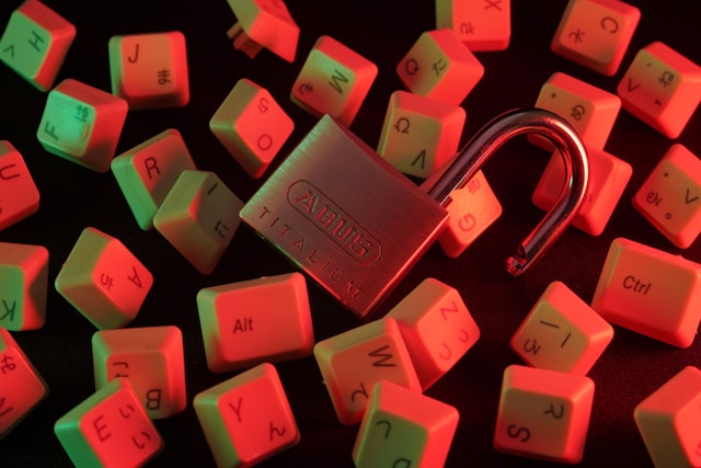 An unlocked padlock sits on top of dislodged keyboard keys.