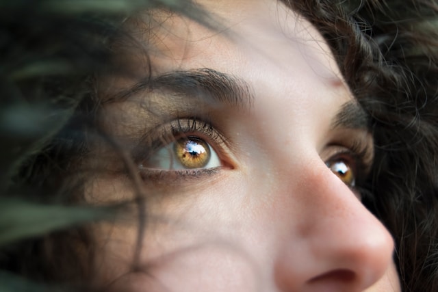 Een close-up, schuine opname van de amberkleurige ogen van een vrouw. 