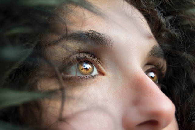 Schräge Nahaufnahme der bernsteinfarbenen Augen einer Frau. 