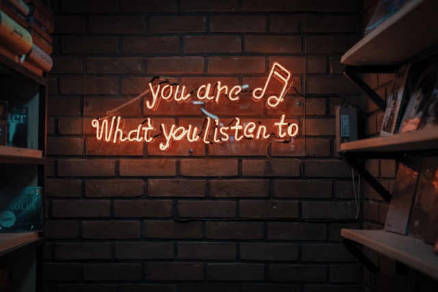 A red neon sign says, “You are what you listen to.”