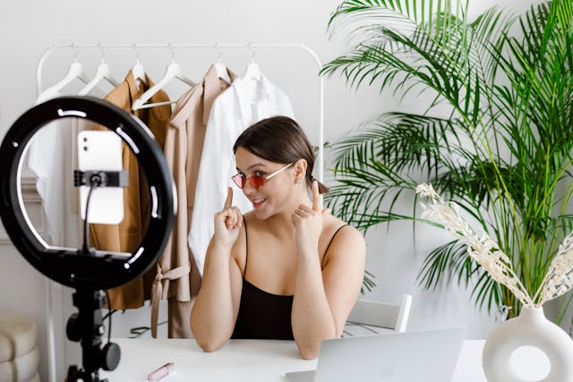 A woman shows off her branded sunglasses for a video.