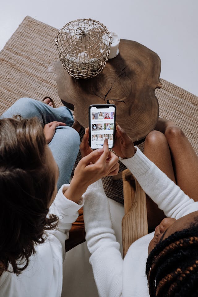 Two friends scroll TikTok on a cell phone.
