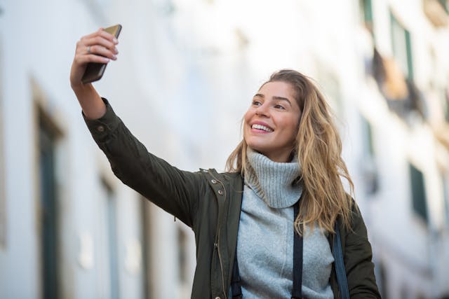 Een vrouw neemt een selfie met haar mobiele telefoon.