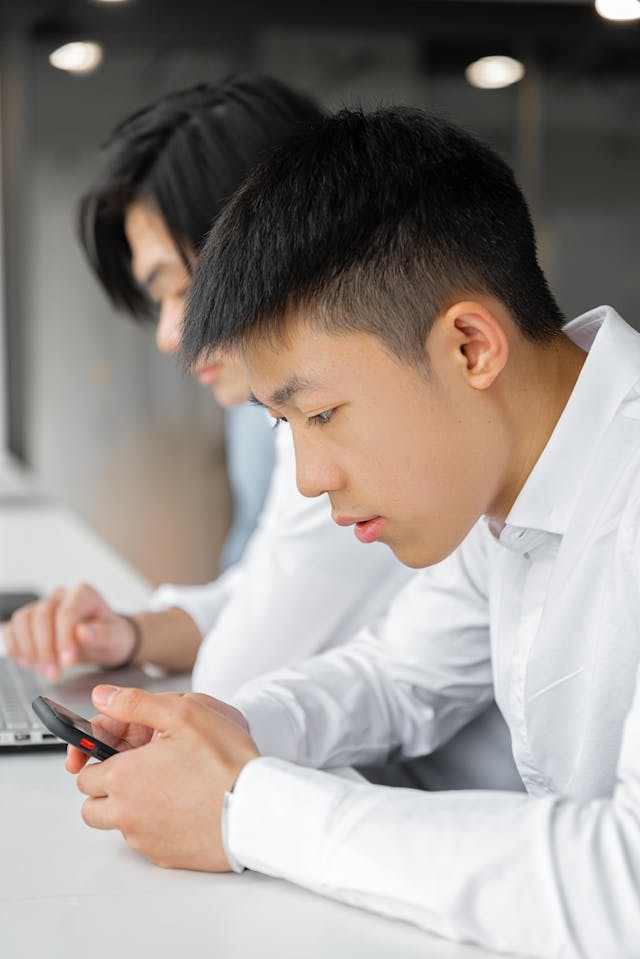 A man scrolls on his phone.
