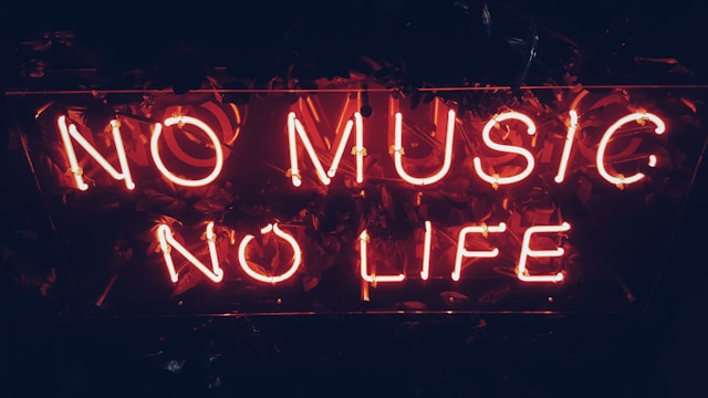 A red neon sign reads, “No music, no life.”
