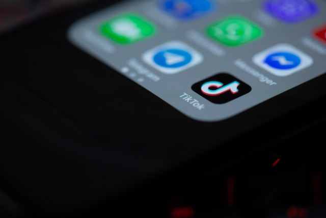 A smartphone displays several social media app tiles including TikTok.