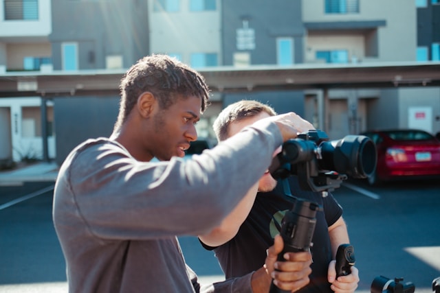 Doi creatori își pregătesc camera DSLR și caută unghiurile potrivite pentru videoclipul lor TikTok. 