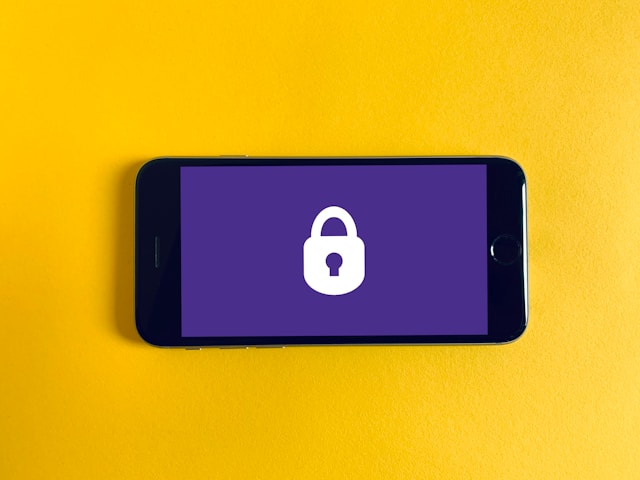Der Bildschirm eines Telefons zeigt ein weißes Vorhängeschloss-Symbol auf lila Hintergrund.