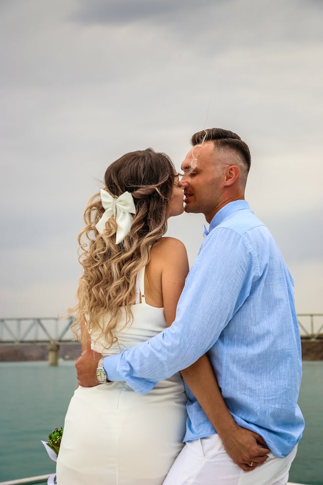 Une femme avec un nœud de cheveux embrasse un homme.