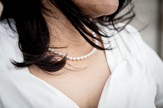 Un collier de perles pend au cou d'une femme.
